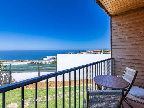 a balcony with a table and chairs and the ocean at Ericeira Coxos Beach Lodge in Santo Isidoro