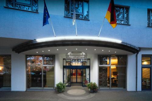 un edificio blu con le bandiere davanti di City Hotel Fortuna Reutlingen a Reutlingen