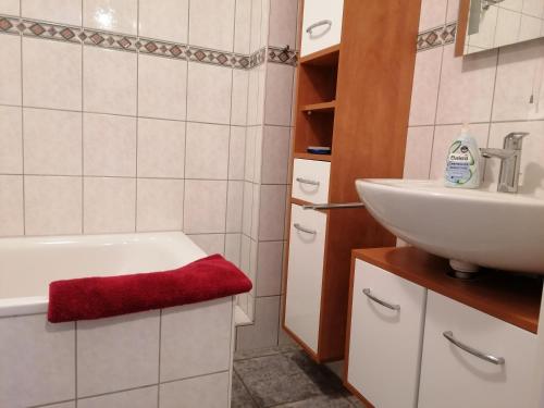 une salle de bain avec une baignoire blanche et un lavabo dans l'établissement Paula - gemütliche Maisonette auf Fehmarn, à Fehmarn