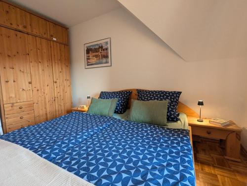 une chambre avec un grand lit avec une couette bleue dans l'établissement Paula - gemütliche Maisonette auf Fehmarn, à Fehmarn