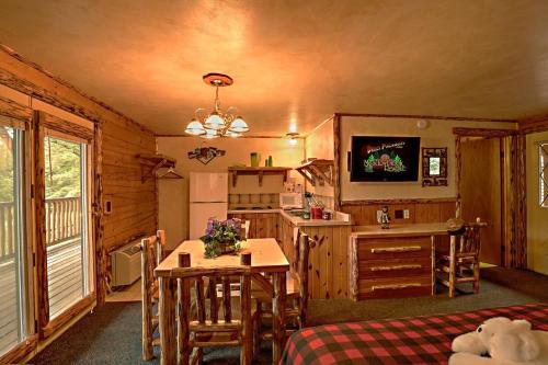 a room with a kitchen and a table in a cabin at Meadowbrook Resort in Wisconsin Dells