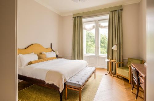 a bedroom with a bed and a desk and a window at Miiro Palais Rudolf NEW OPENING in Vienna