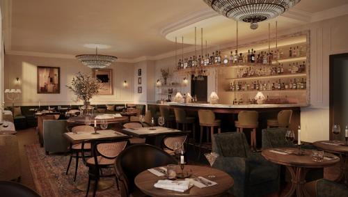 a restaurant with tables and chairs and a bar at Miiro Palais Rudolf NEW OPENING in Vienna