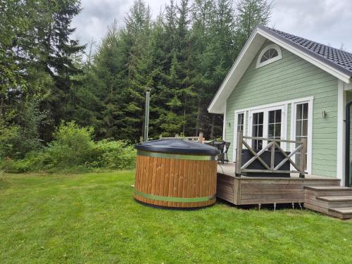a hot tub on a deck next to a house at Tosthult Holiday in Lönsboda