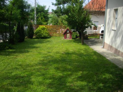 a yard with a dog house in the grass at House Hévíz in Hévíz