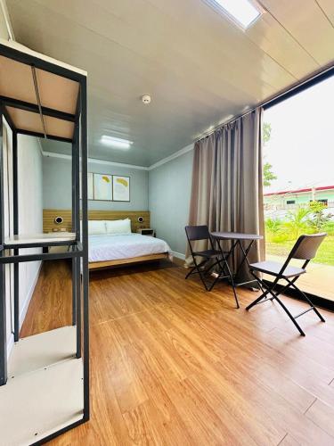 a bedroom with a bed and a table and chairs at Ooni Hostel Moalboal in Moalboal