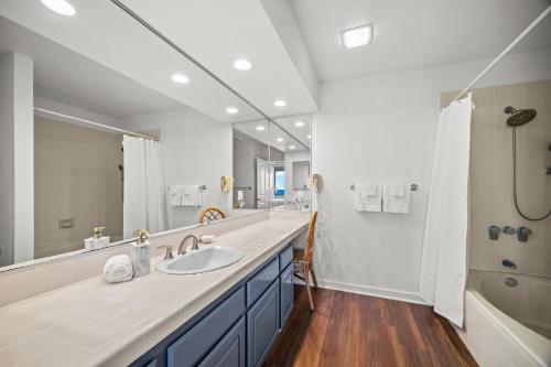 ein Badezimmer mit Waschbecken und großem Spiegel in der Unterkunft Makanui 221 in Kipu