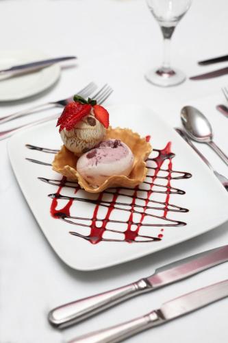 a white plate with a dessert on a table at Lastra Farm Hotel in Amlwch
