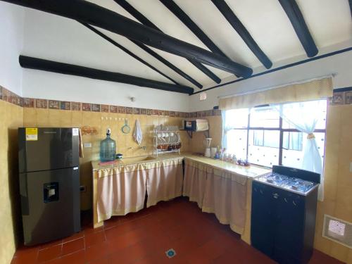 eine Küche mit einem schwarzen Kühlschrank und einem Fenster in der Unterkunft Apartamento Eucalyptus in Villa de Leyva