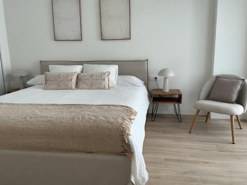 a bedroom with a bed and a chair at Esmeralda Sea Villa - Beach&Golf Sancti Petri in Novo Sancti Petri