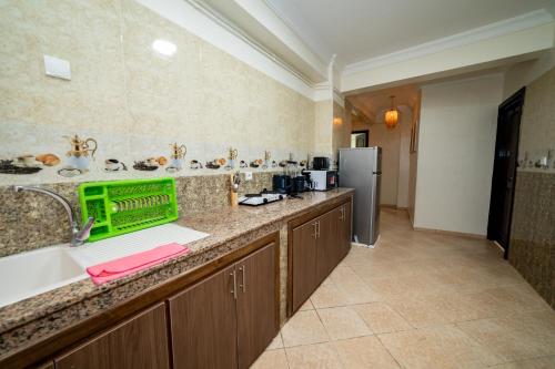a large kitchen with a sink and a refrigerator at Appartement Dar Tamraght in Tamraght Ouzdar