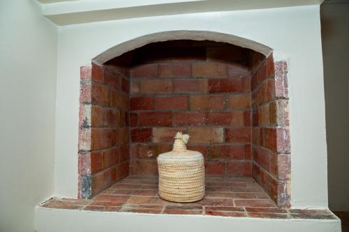 a brick fireplace with a vase on top of it at Appartement Dar Tamraght in Tamraght Ouzdar