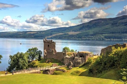 a castle on a hill next to a body of water at Central City Apartment - Inverness centre in Inverness