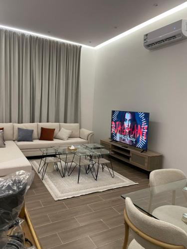 un salon avec un canapé et une télévision dans l'établissement شقة مفروشة فاخره, à Hafr Al Baten