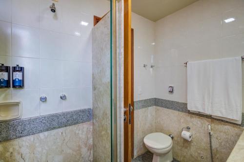 a bathroom with a toilet and a shower at Slaviero Londrina Flat in Londrina
