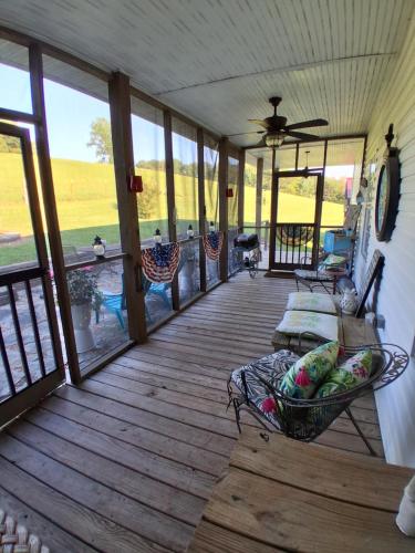 a screened in porch with a couch and chairs on it at Flatt Creek Cottage in Livingston