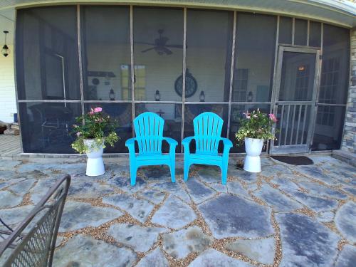 two blue chairs sitting on a patio with flowers at Flatt Creek Cottage in Livingston