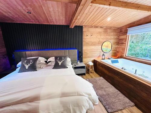 a bedroom with a large bed and a tub at Bijoux Des Alpes - Mont Blanc Village in La Salle