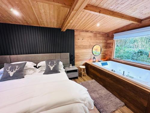 a bedroom with a bed and a bath tub at Bijoux Des Alpes - Mont Blanc Village in La Salle