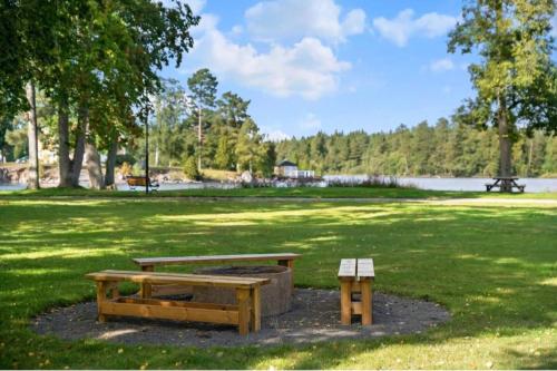a picnic table and a bench in a park at Renovated Lake view Retreat with Kayaks & Big Garden in Klavreström