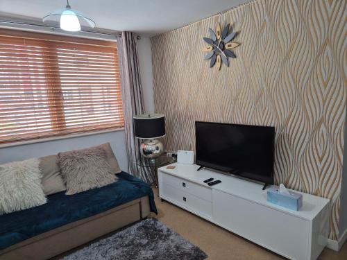 una camera da letto con un letto e una televisione su una cassettiera di 2 bed GF Docklands Apartment - Free Parking for 1 car a Liverpool