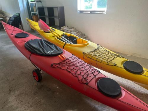 three kayaks are lined up in a room at Renovated Lake view Retreat with Kayaks & Big Garden in Klavreström