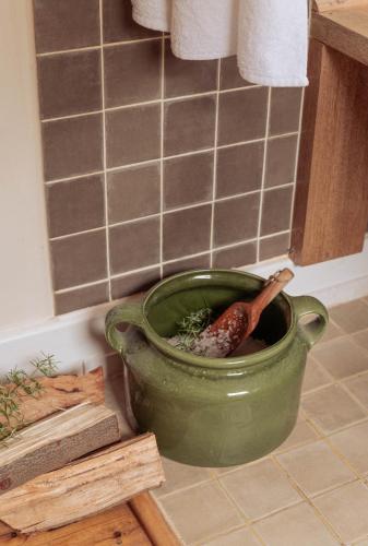 a green pot on a kitchen counter with a sausage in it at Stoep By Ideas Cartel in Kalk Bay