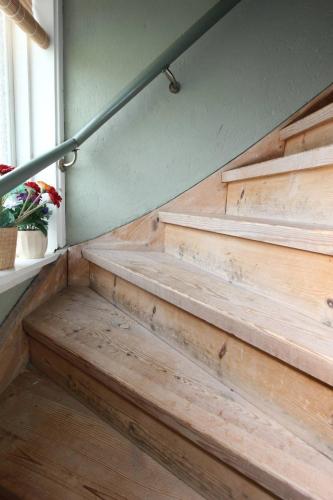 a set of wooden stairs with a window and a plant at Renovated Lake view Retreat with Kayaks & Big Garden in Klavreström