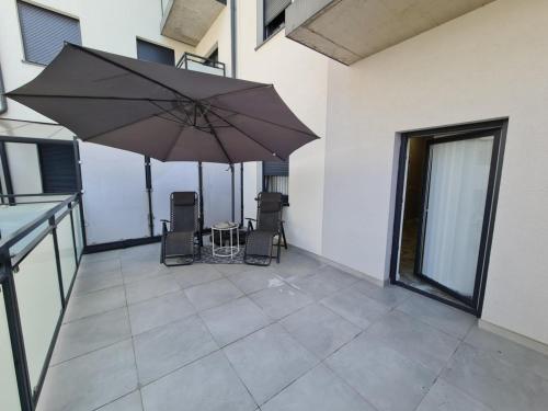 a patio with a table and chairs and an umbrella at Apartament in Legnica