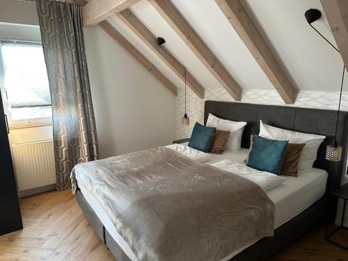 a bedroom with a large bed with blue pillows at Gästehaus Huber in Immenstaad am Bodensee