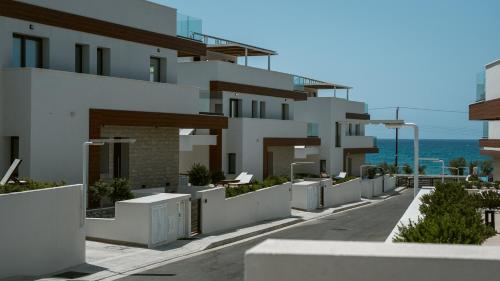 a white building with the ocean in the background at Santa Barbara Seafront villas w jacuzzi pool in Paphos City