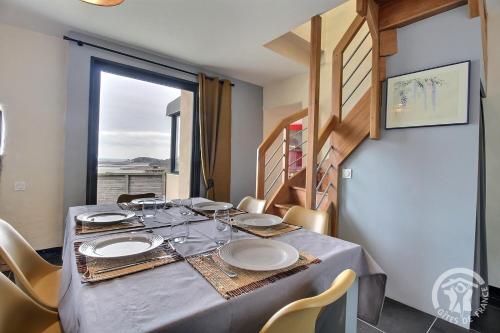 una sala da pranzo con tavolo e sedie e una finestra di Ty maï a Louannec