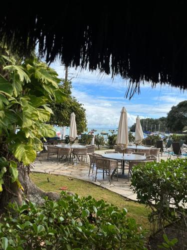 a group of tables and chairs with white umbrellas at Pousada Corsario Buzios in Búzios
