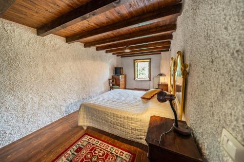 Rovere VeroneseVilla Storica immersa nella Natura Veronese的一间带床的卧室，位于带木质天花板的房间内