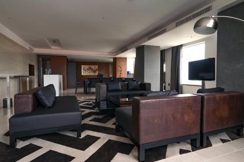 a lobby with couches and chairs and a television at Holiday Inn Gwangju by IHG in Gwangju