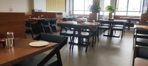 a dining room with tables and chairs in a restaurant at Hotel Sara Executive in Pune