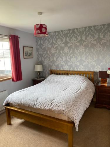 a bedroom with a bed and a red lamp at Caledonia House in Rosyth