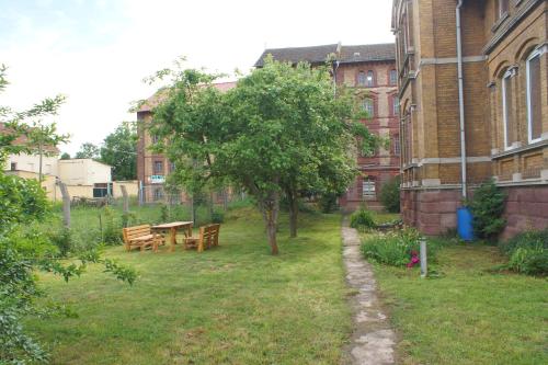 a garden with a table and a tree in front of a building at Alte Mühle Kelbra - ehemalig ALBIG in Kelbra