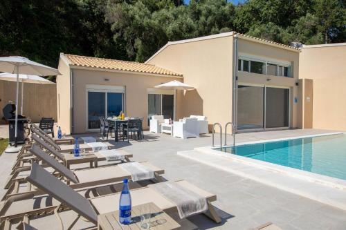 a villa with a swimming pool and a patio at Valtes Blue by Vintage Travel in Corfu