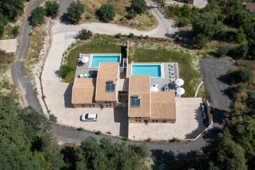 an aerial view of a house with two swimming pools at Valtes Blue by Vintage Travel in Corfu