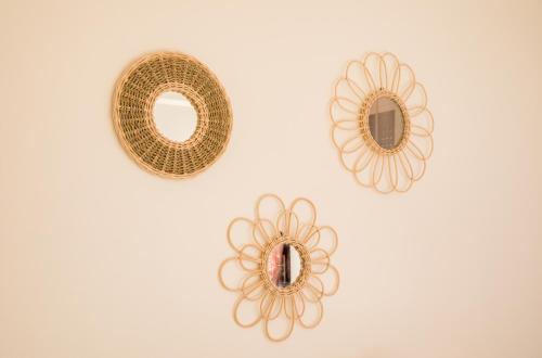 two gold plates and a mirror on a wall at Appartement Dar Tamraght in Tamraght Ouzdar