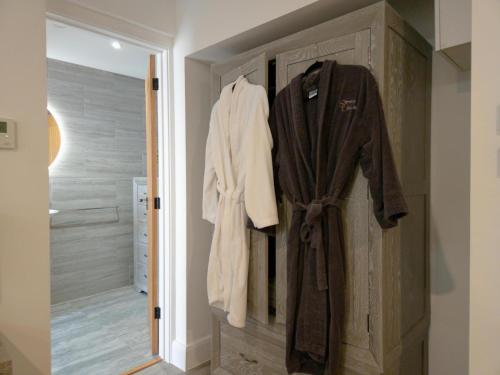 a bathroom with a robe hanging on a door at Suite 14 - Sleeping Giant Hotel - Pen Y Cae Inn in Brecon