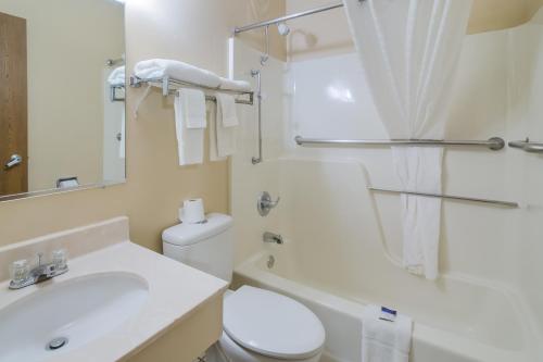 a white bathroom with a toilet and a sink at Americas Best Value Inn Fargo in Fargo