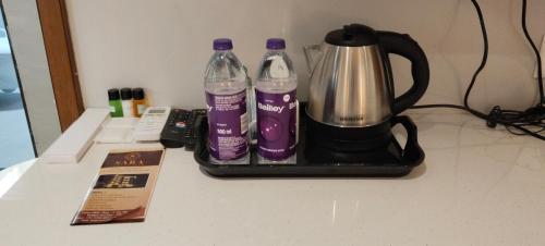 a coffee maker and two bottles of water on a counter at Hotel Sara Executive in Pune