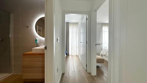 a white bathroom with a sink and a mirror at CoruñaFlat Apartamentos con encanto en el centro de A Coruña in A Coruña