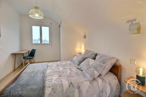 a bedroom with a bed and a desk and a window at Les acacias in Lamballe Armor