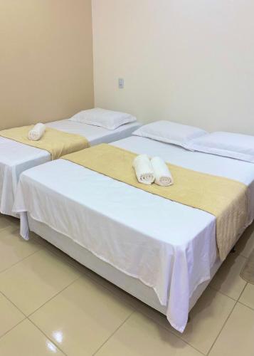 two beds sitting next to each other in a room at Suite no Centro da Praia de Flecheiras in Trairi
