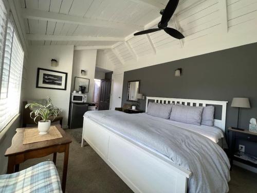 a bedroom with a large white bed and a table at The Midtown Cottage- w/ Private Entrance and Views in Santa Cruz