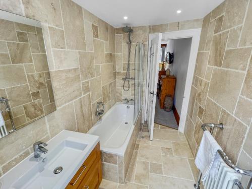 リントンにあるPenthouse Lynmouth Bayの浴槽、洗面台、シャワーを備えたバスルーム