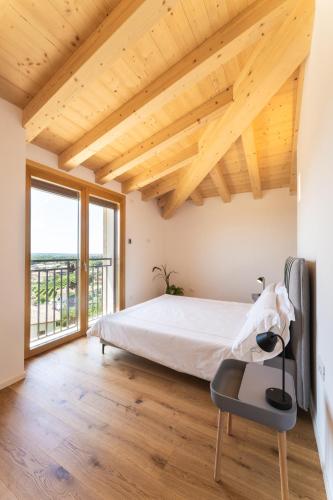 a bedroom with a bed and a large window at IL Pollaio in Farra di Soligo